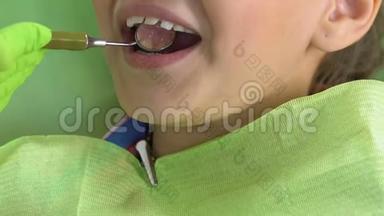 兴奋的孩子坐在牙科椅上，医生用特殊的镜子检查牙齿